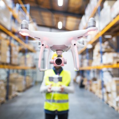 Man with drone in a warehouse.